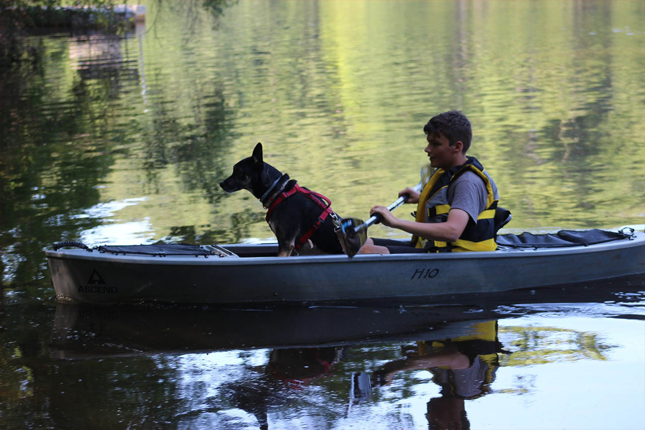 Camper kayaking with a dog on Aldrich Mill Pond at Sutton Falls Camping Area